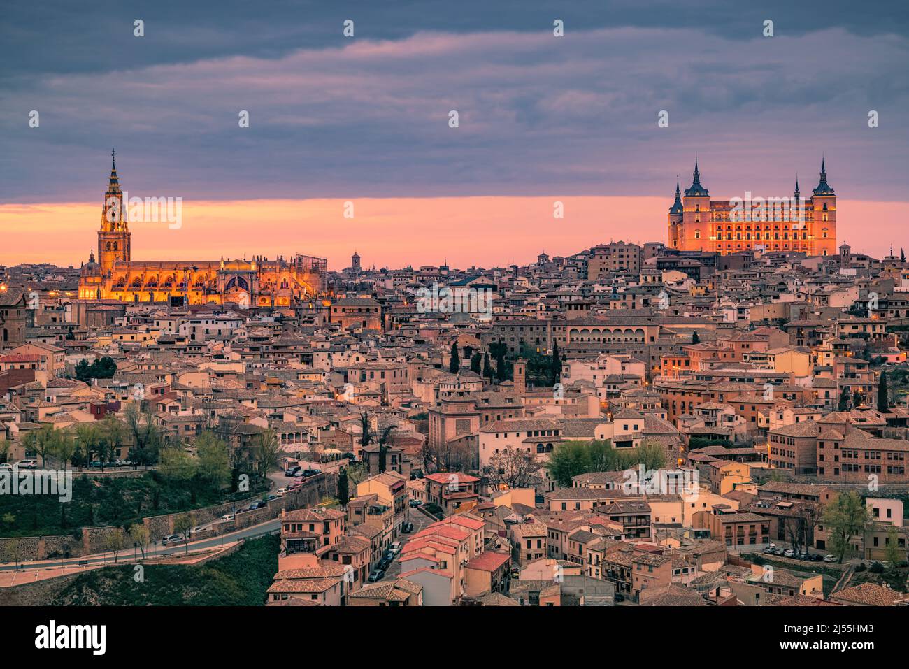 An evening in Toledeo with the view towards the Cathedral (Catedral de Santa María de Toledo) and the Alcazar of Toledo. The Alcázar of Toledo is a st Stock Photo