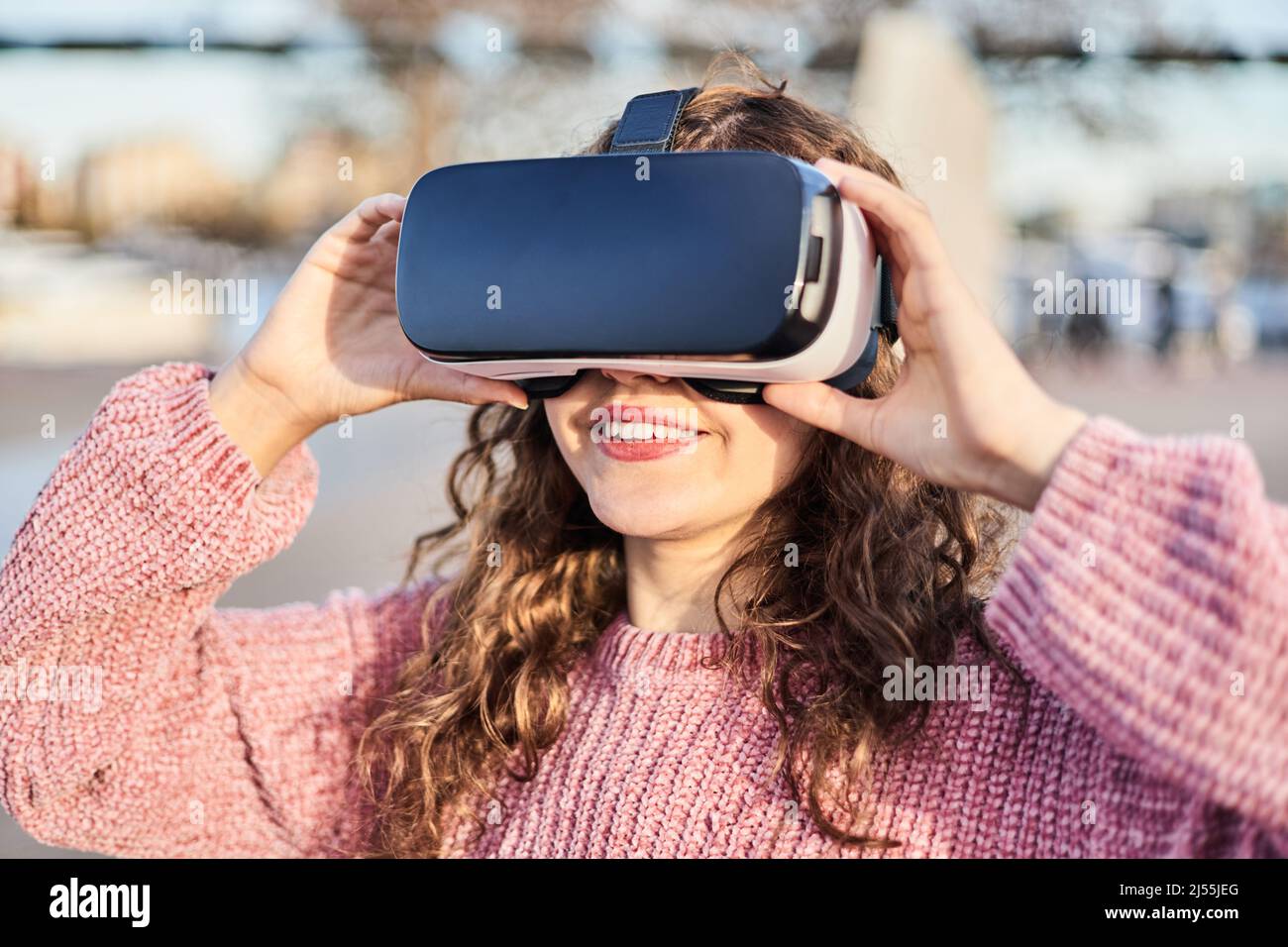 Young girl with VR goggles ready to enter the virtual world. Concept of metaverse. Stock Photo