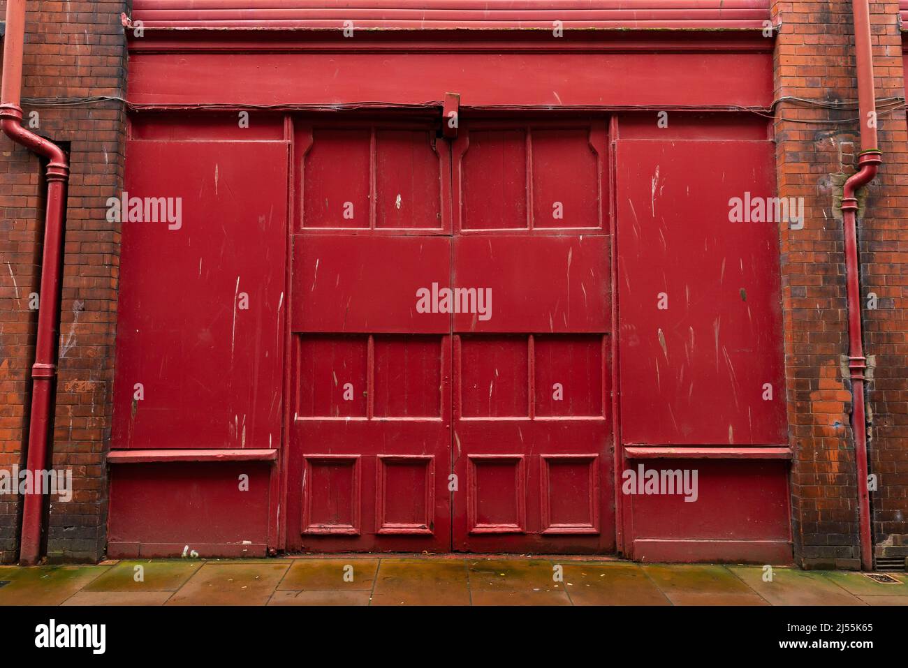 Red industrial doors on old brick building in English city. Carlisle, England. Stock Photo