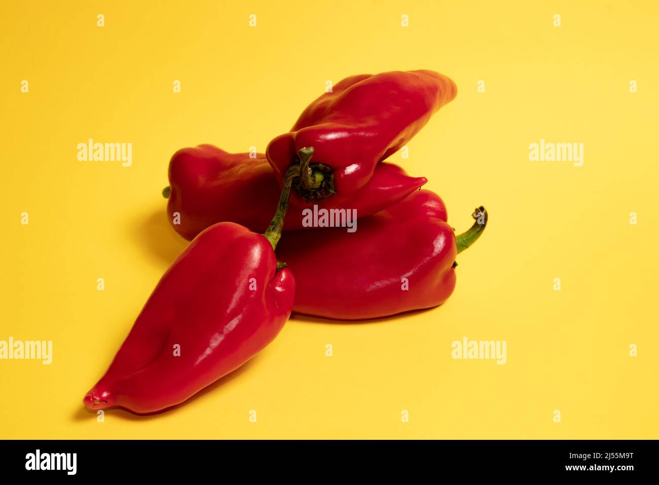Fresh red paprika. Yellow background. Stock Photo