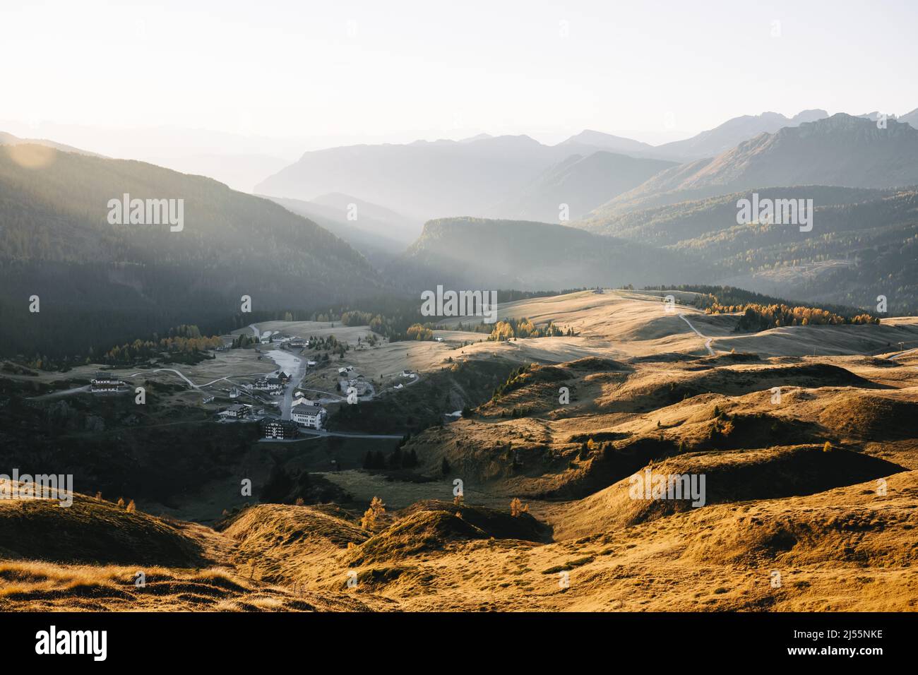 Aerial flyght over italian Dolomite mountains in sunset time. Orange hills glowing by sunset light. San Martino di Castrozza, Dolomites, Trentino, Italy. Landscape photography Stock Photo