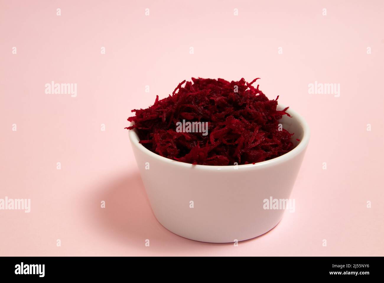 Grated beets in a white bowl Stock Photo
