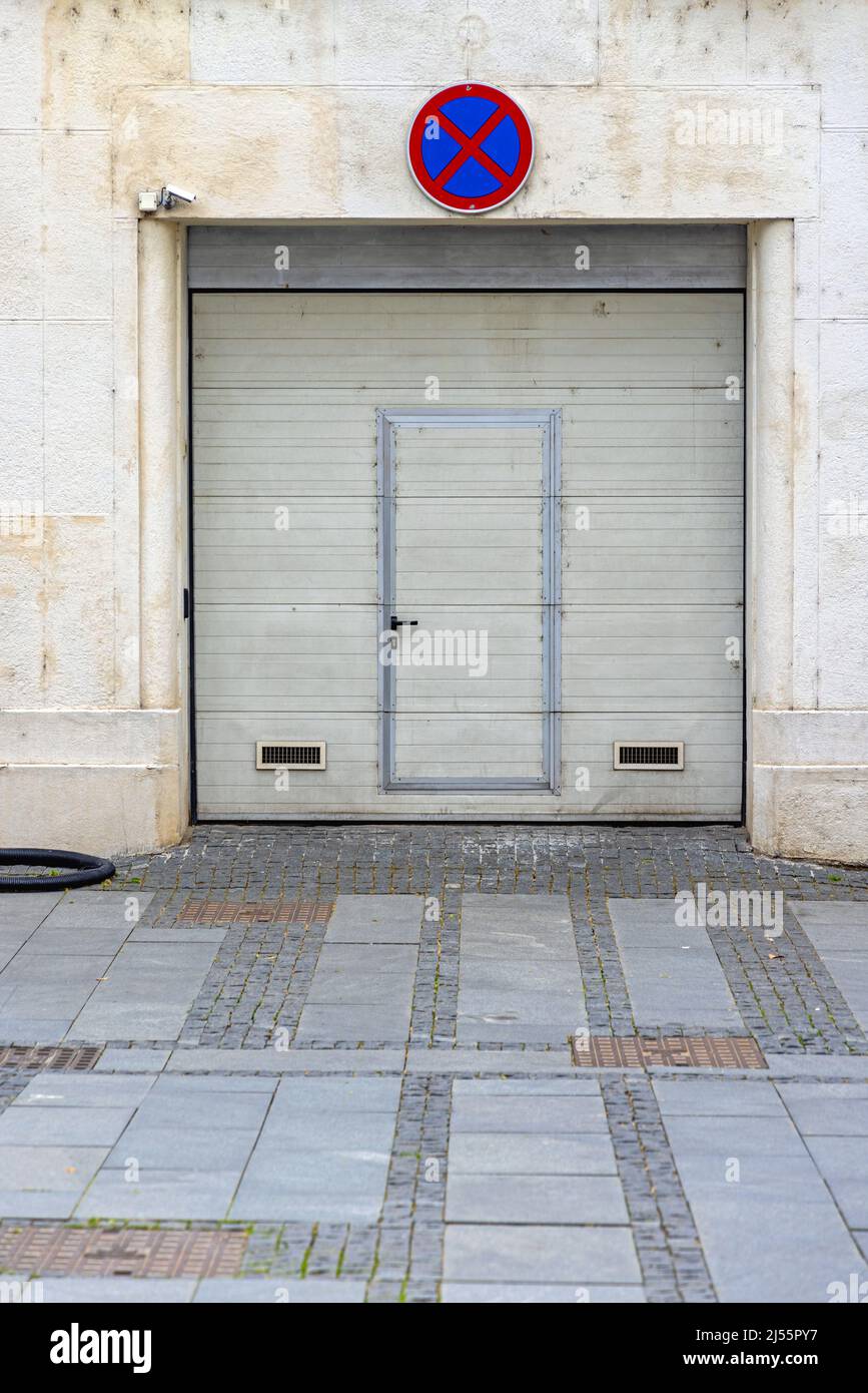 Automated Garage Roll Doors With Small Door Built in Parking Sign Stock Photo