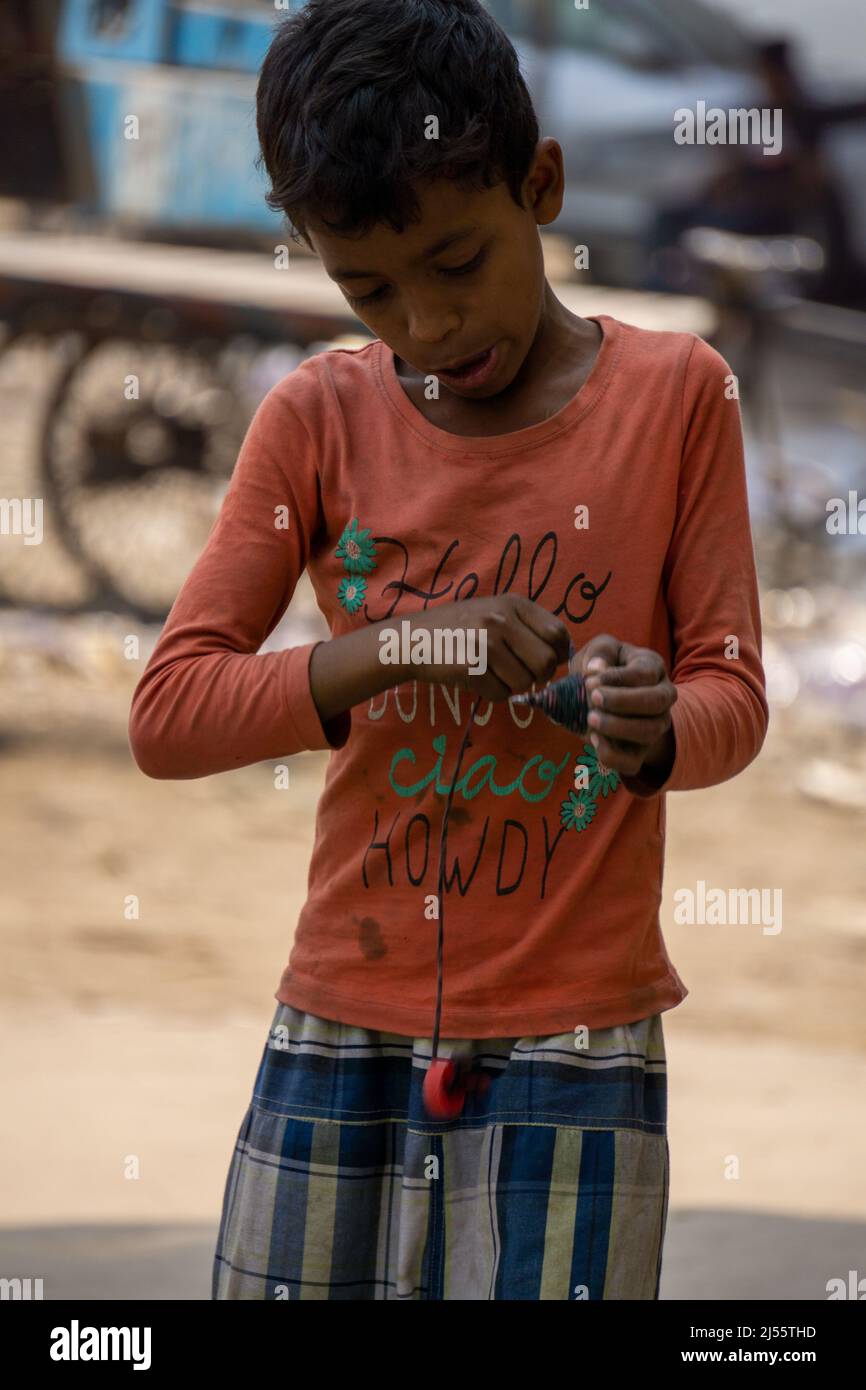Bangladeshi Urban Child. A child is making a latim to turn. Pictures of Dhaka city. Stock Photo