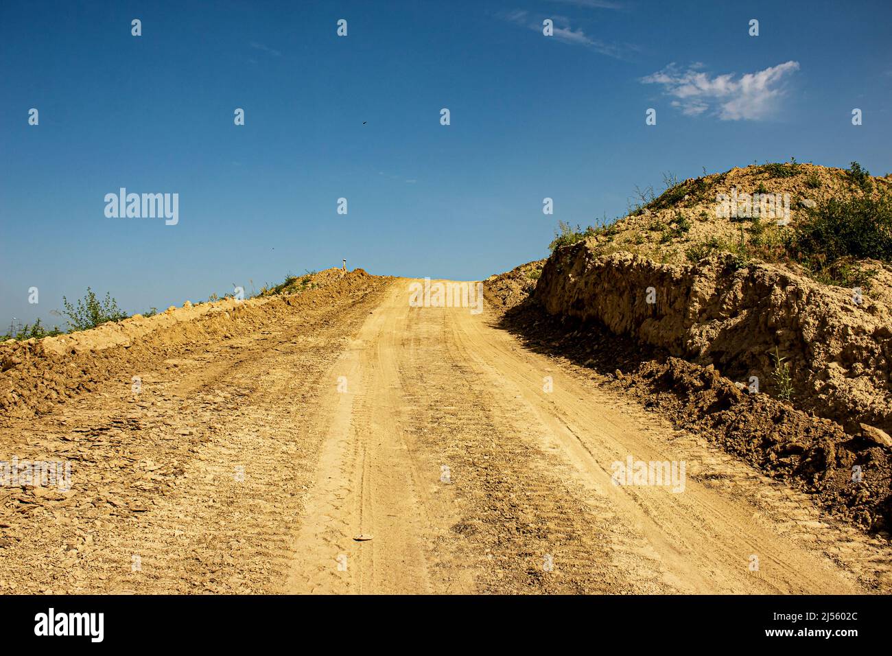A temporary road made of clay soil during the construction of a road
