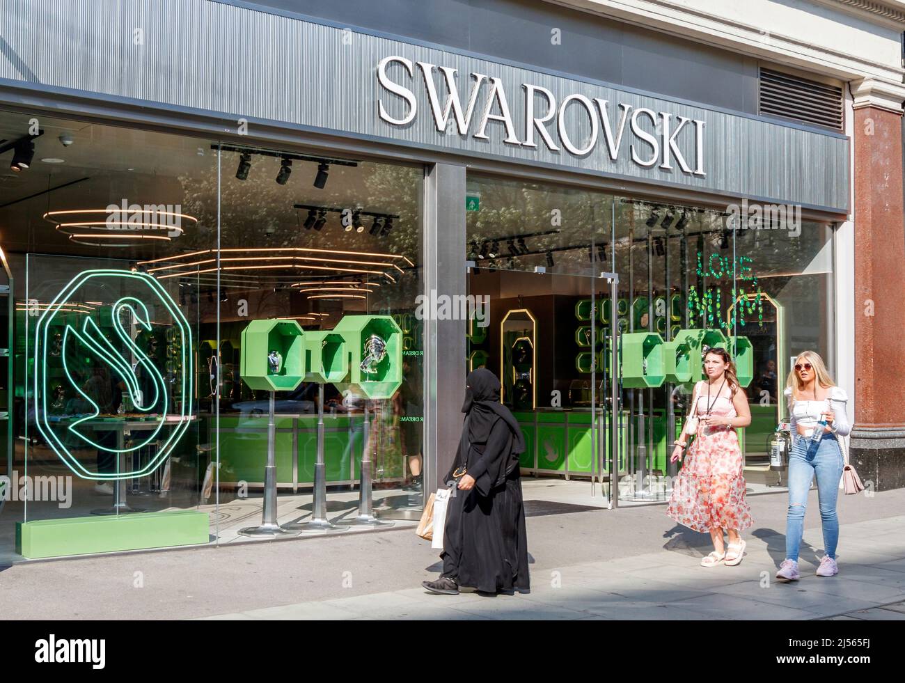 Three women walking past a branch of Swarovski, a retailer seller crystal  glass, jewellery and accessories, in Oxford Street, London, UK Stock Photo  - Alamy