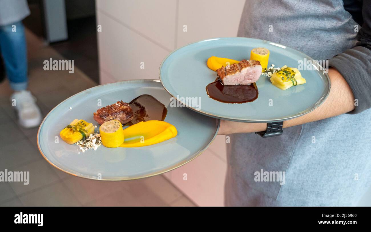 Kitchen of an upscale restaurant, plate with a meat dish is served, Stock Photo