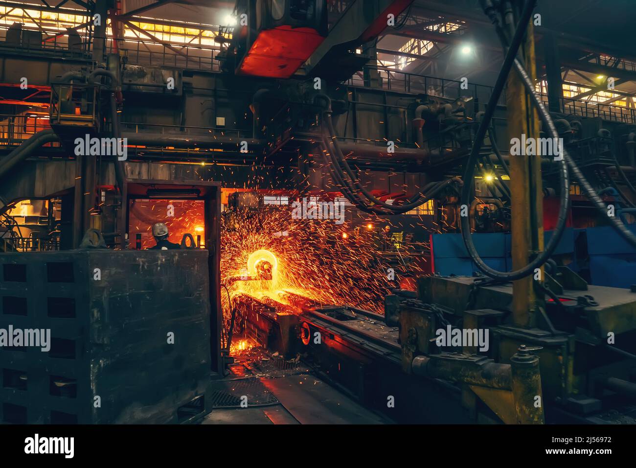 Metal casting in metallurgical plant or factory. Process of melting and forming production of iron pipes in industrial machines in workshop. Stock Photo