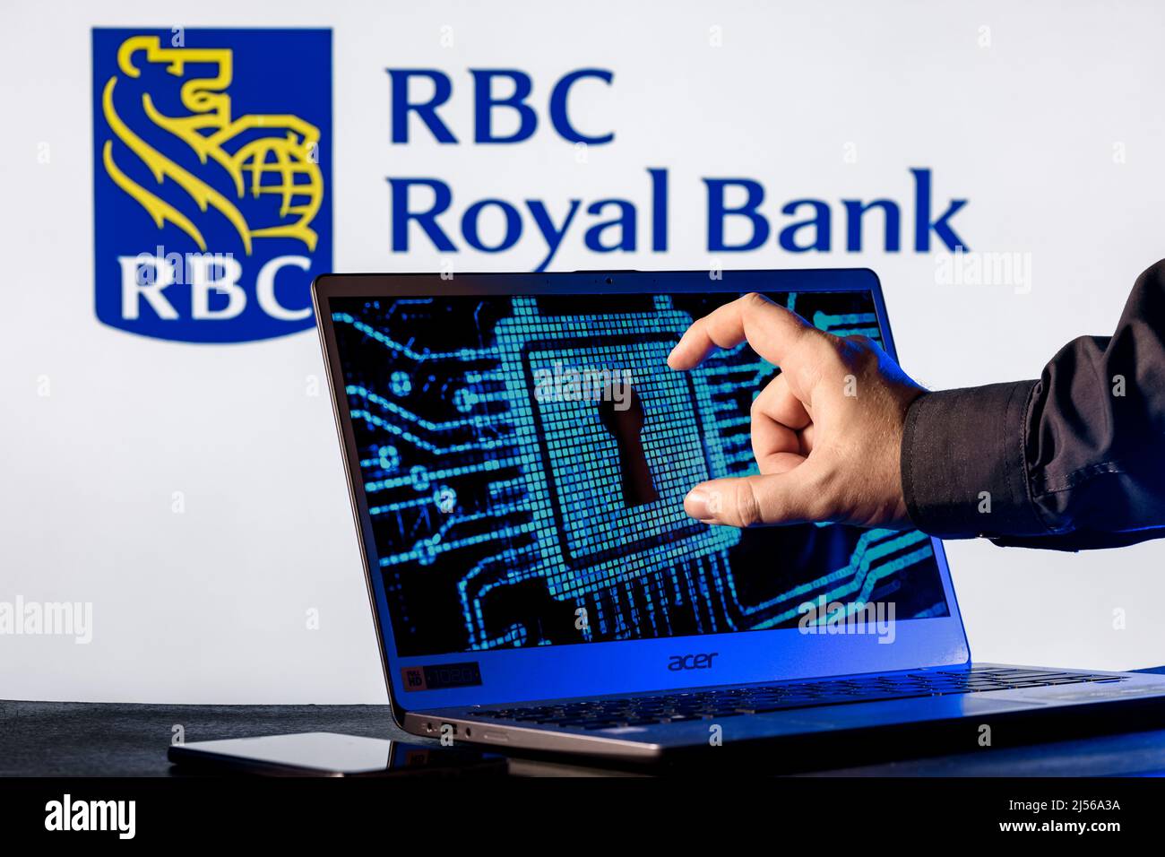 Laptop with lock symbol on screen on background of Royal Bank of Canada logo. Finger points to lock symbol. Concept of data hacking. Stock Photo