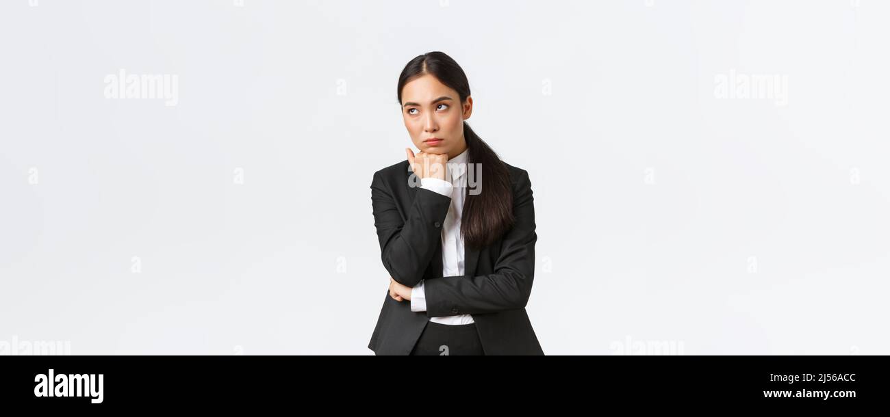Bored and annoyed female entrepreneur looking unamused away while sitting boring meeting, attend uninteresting office gathering, standing white Stock Photo