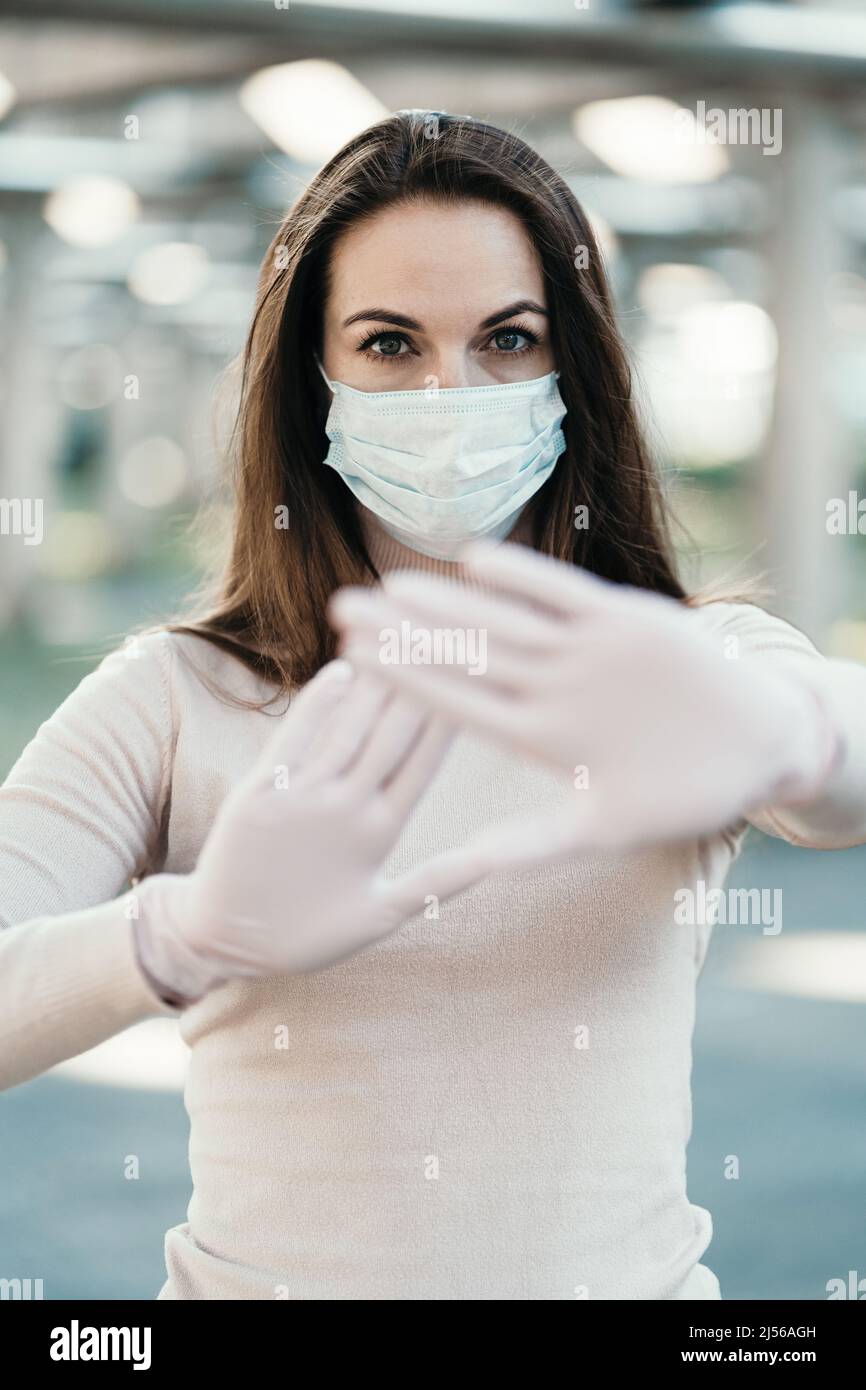 Young girl in medical mask and gloves shows the logo of coronavirus ...