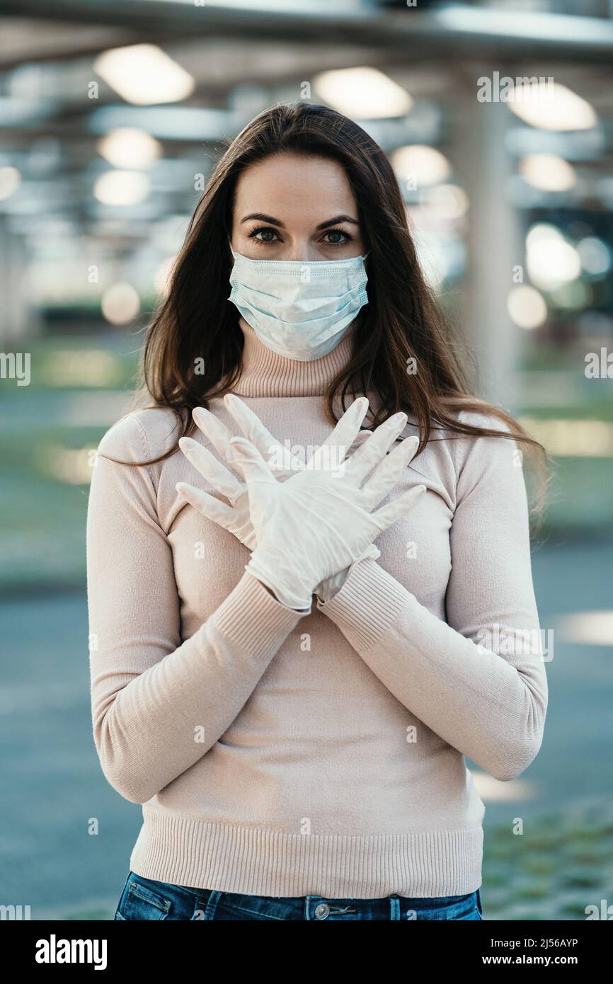 Young girl in medical mask and gloves shows the logo of coronavirus ...