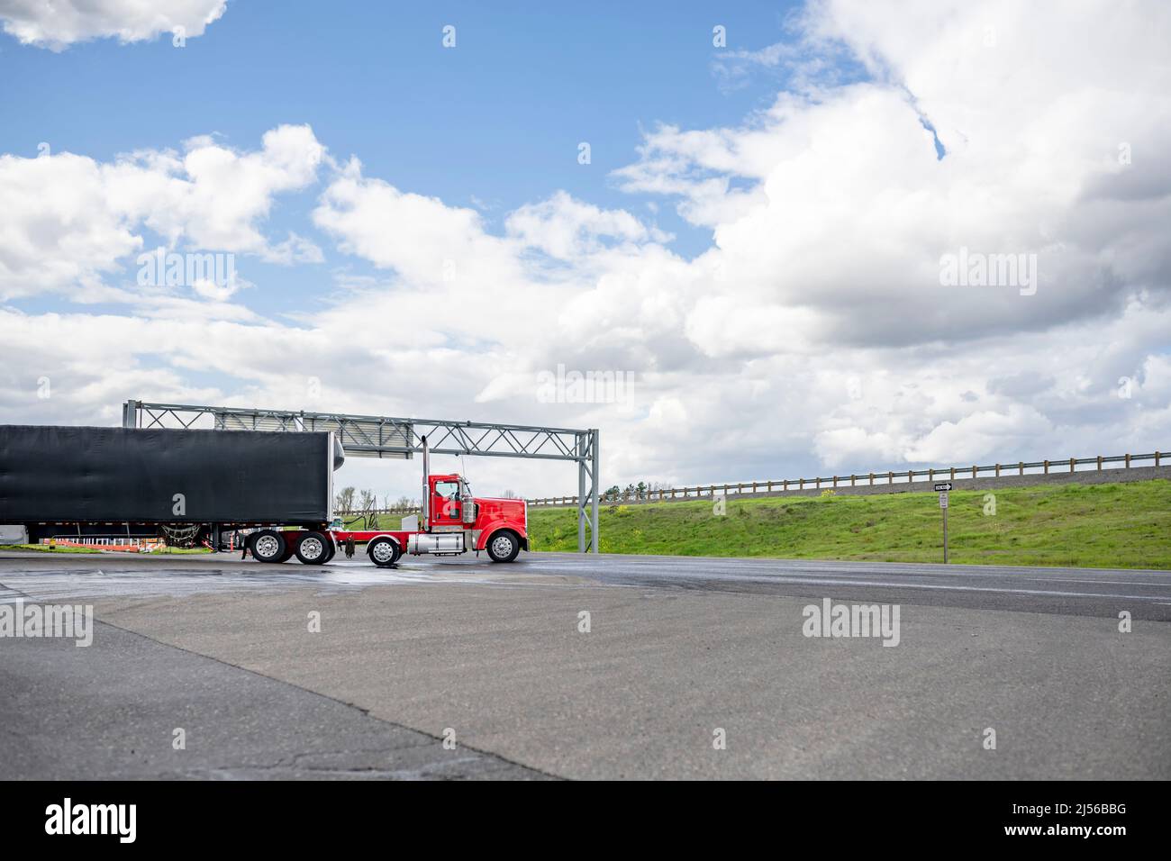 Long haul professional classic industrial standard red big rig semi truck tractor with loaded dry van semi trailer transporting commercial cargo turni Stock Photo