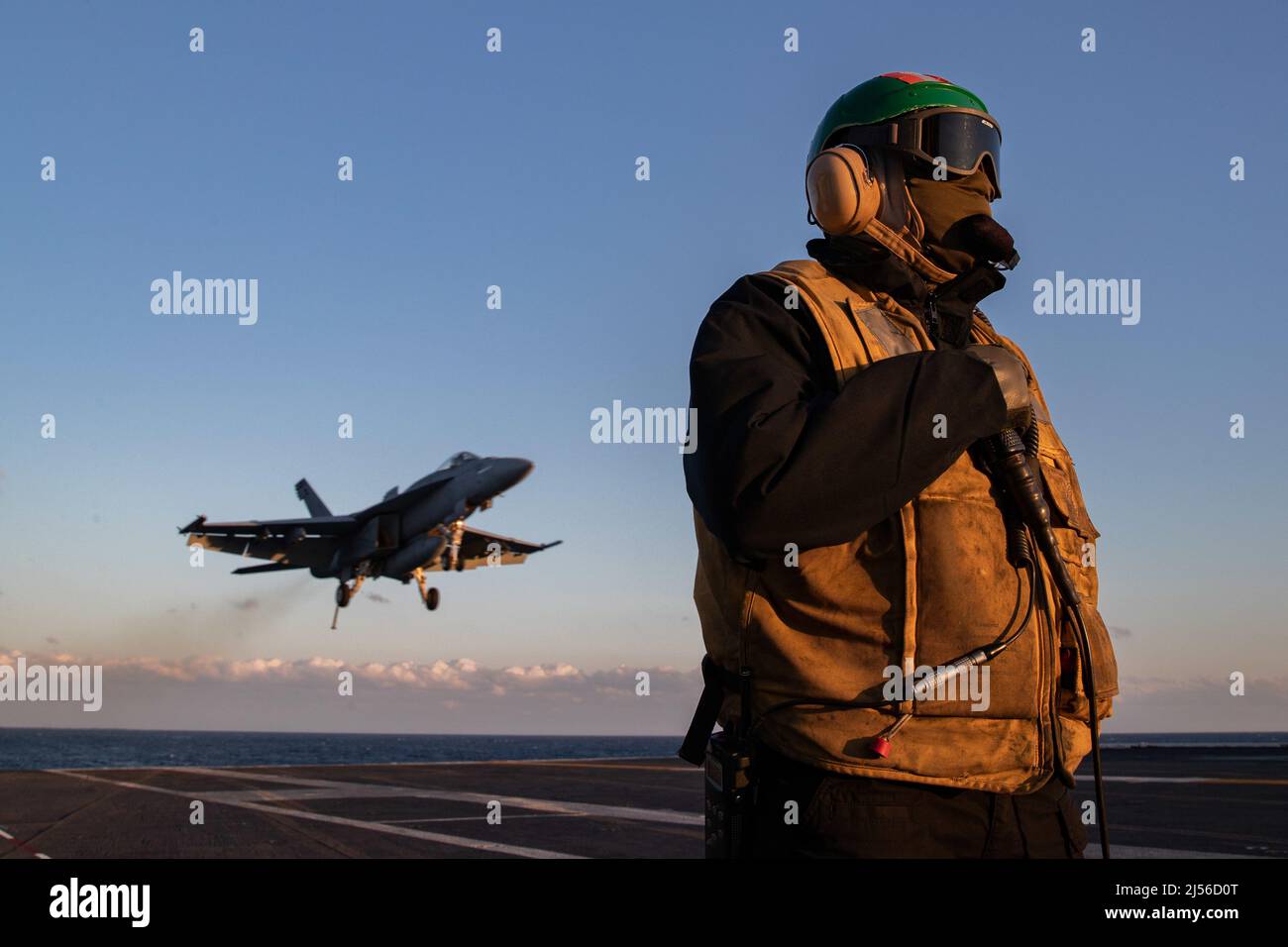 Aviation Boatswain's Mate (Equipment) 1st Class Aaron Wilson, from Atlanta, assigned to USS Gerald R. Ford’s (CVN 78) air department, stands watch as the arresting gear officer as an F/A-18E Super Hornet, attached to the 'Golden Warriors' of Strike Fighter Squadron (VFA) 87, prepares to land on the flight deck, April 19, 2022. Ford is underway in the Atlantic Ocean conducting carrier qualifications and strike group integration as part of the ship’s tailored basic phase prior to operational deployment. (U.S. Navy photo by Mass Communication Specialist 2nd Class Zachary Melvin) Stock Photo