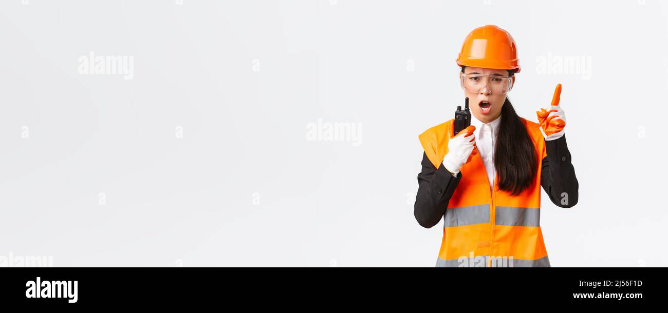 Serious-looking asian female industrial engineer, technician in safety ...