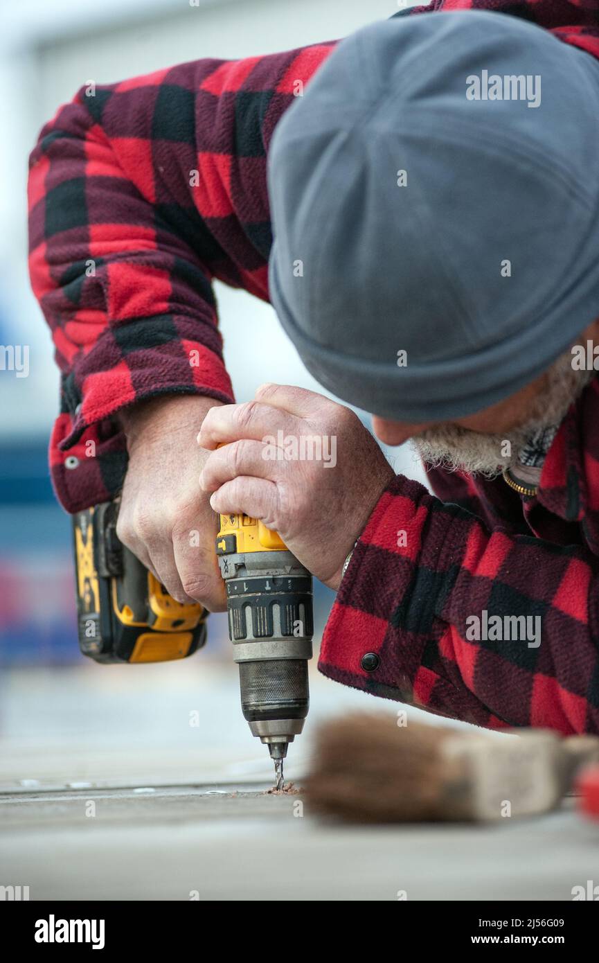 tradesman using battery electric drill Stock Photo