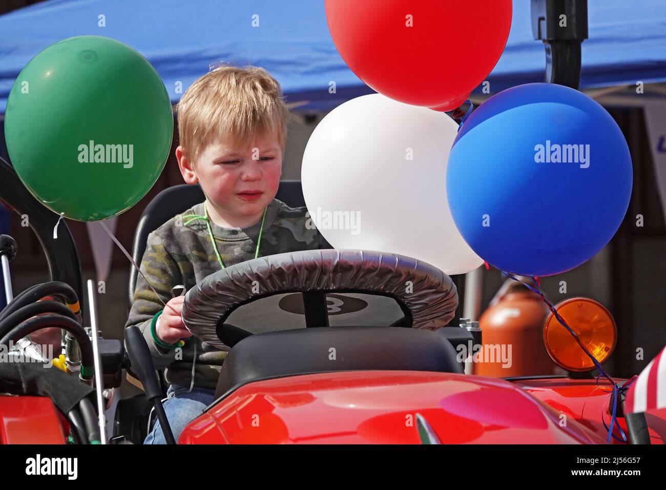 A little boy play driving a farm tractor at a small country fair in Redmond, Oregon Stock Photo