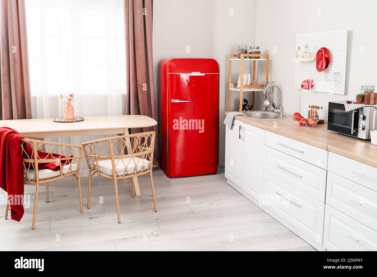 Interior of light kitchen with retro fridge, white counters and dining ...