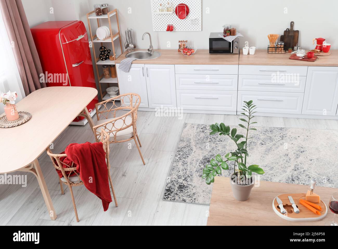 Interior of light kitchen with retro fridge, white counters and dining ...