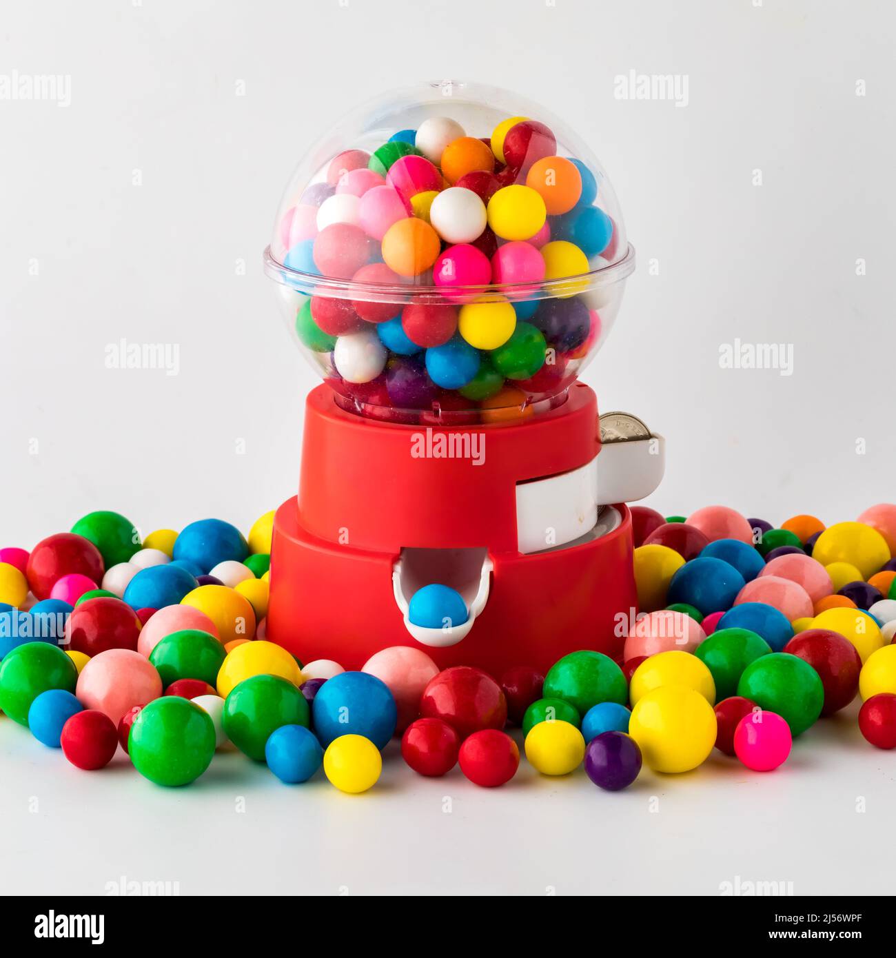 A toy gum ball machine filled with and surrounded by gum balls. Stock Photo