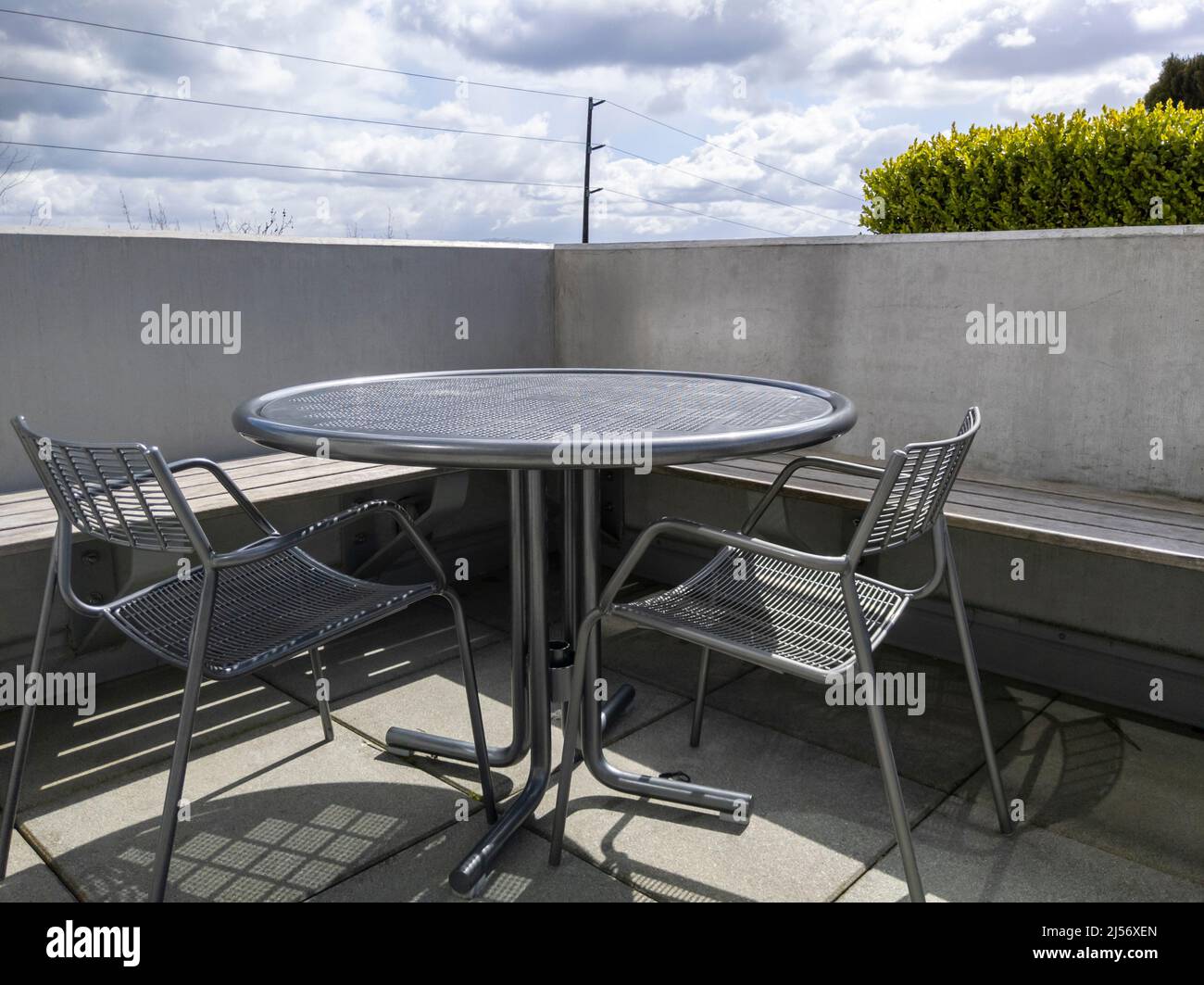 View of a rooftop balcony with a round, metal table and two chairs
