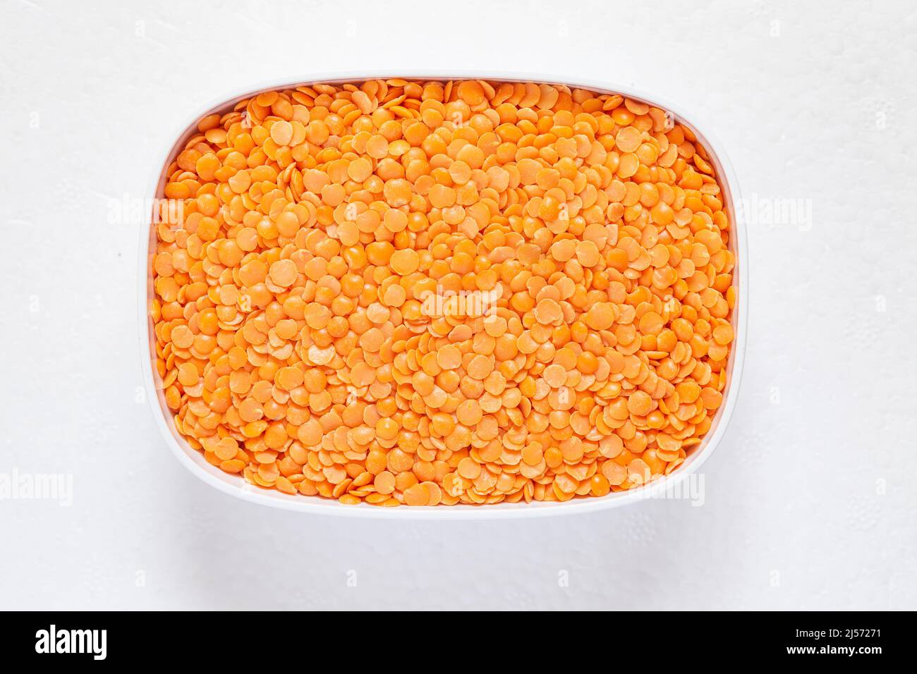 Red split lentil close-up in a plate. Stock Photo