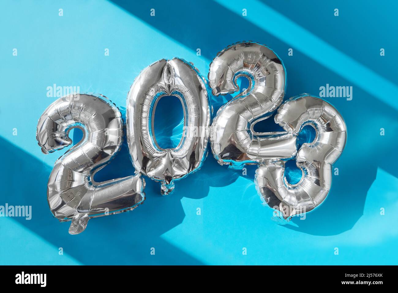 Happy New year 2023 celebration sunshine's bright light. Silver balloons figures, New Year Balloons Christmas and new year celebration. Silver foil ba Stock Photo
