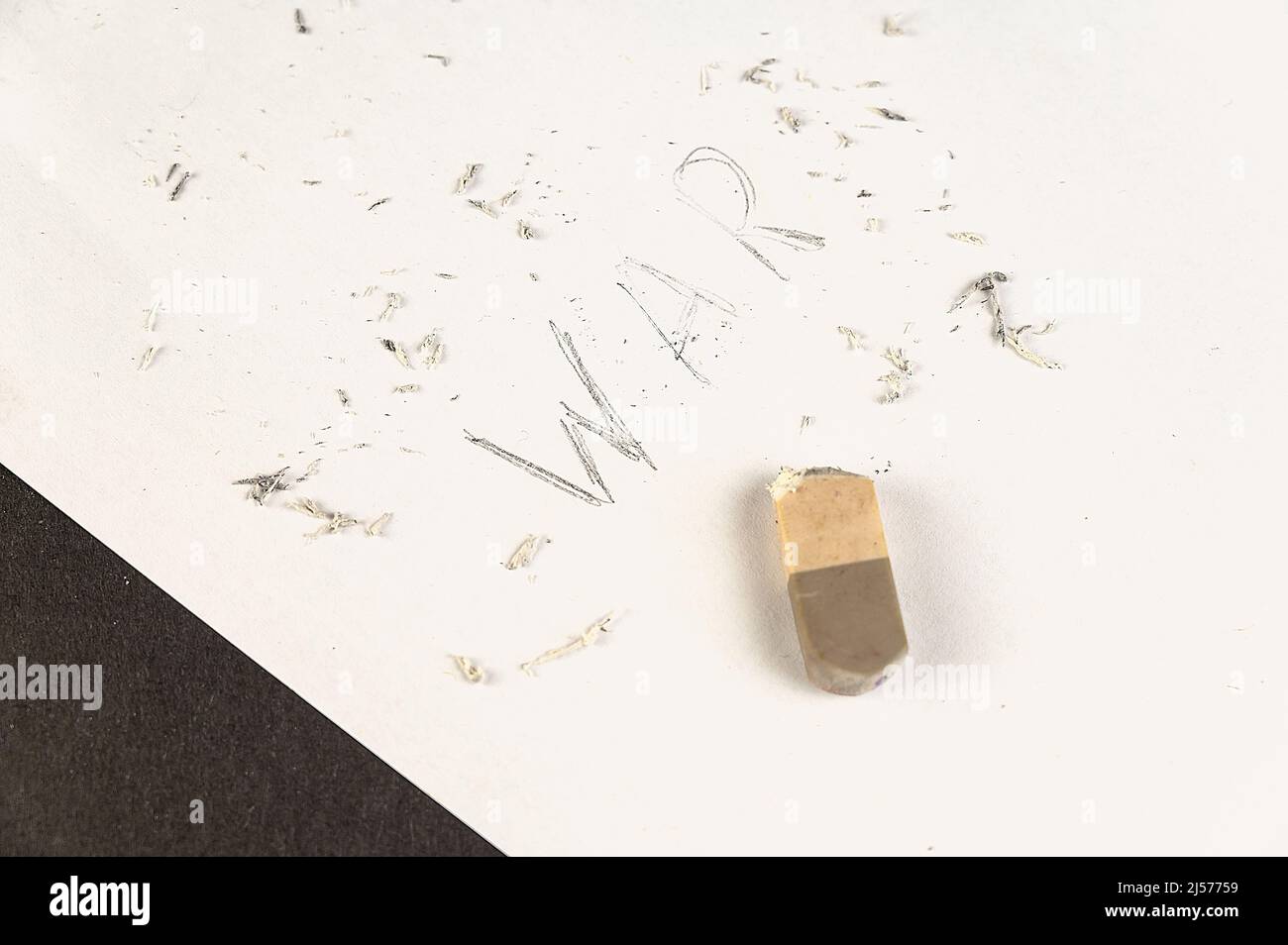 Halferased with an eraser is the word WAR. Handwritten word on white