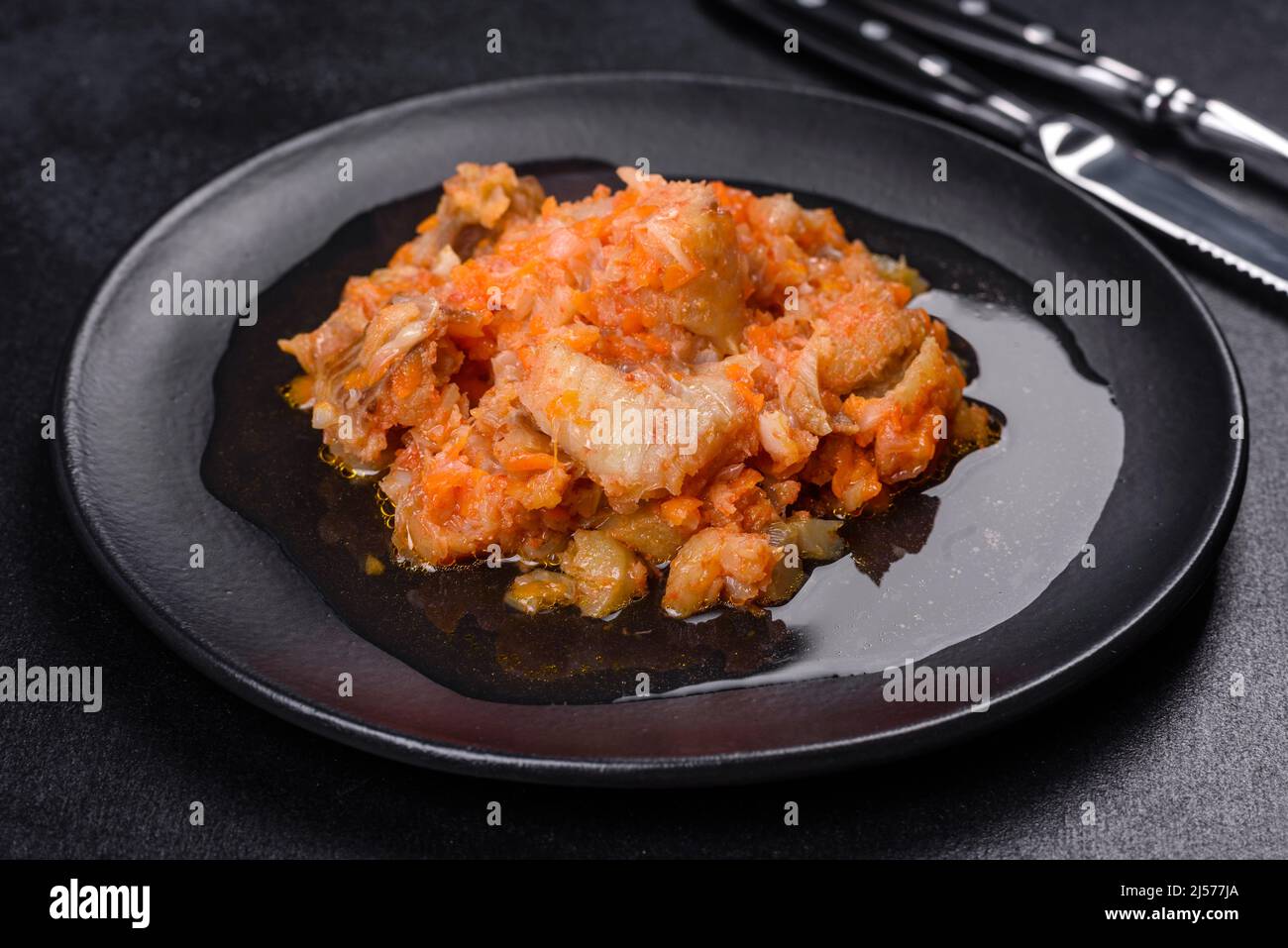 Baked hake white fish with tomato n the black background Stock Photo