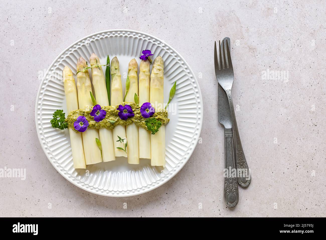 White asparagus with italian pesto sauce and edible flowers. Stock Photo