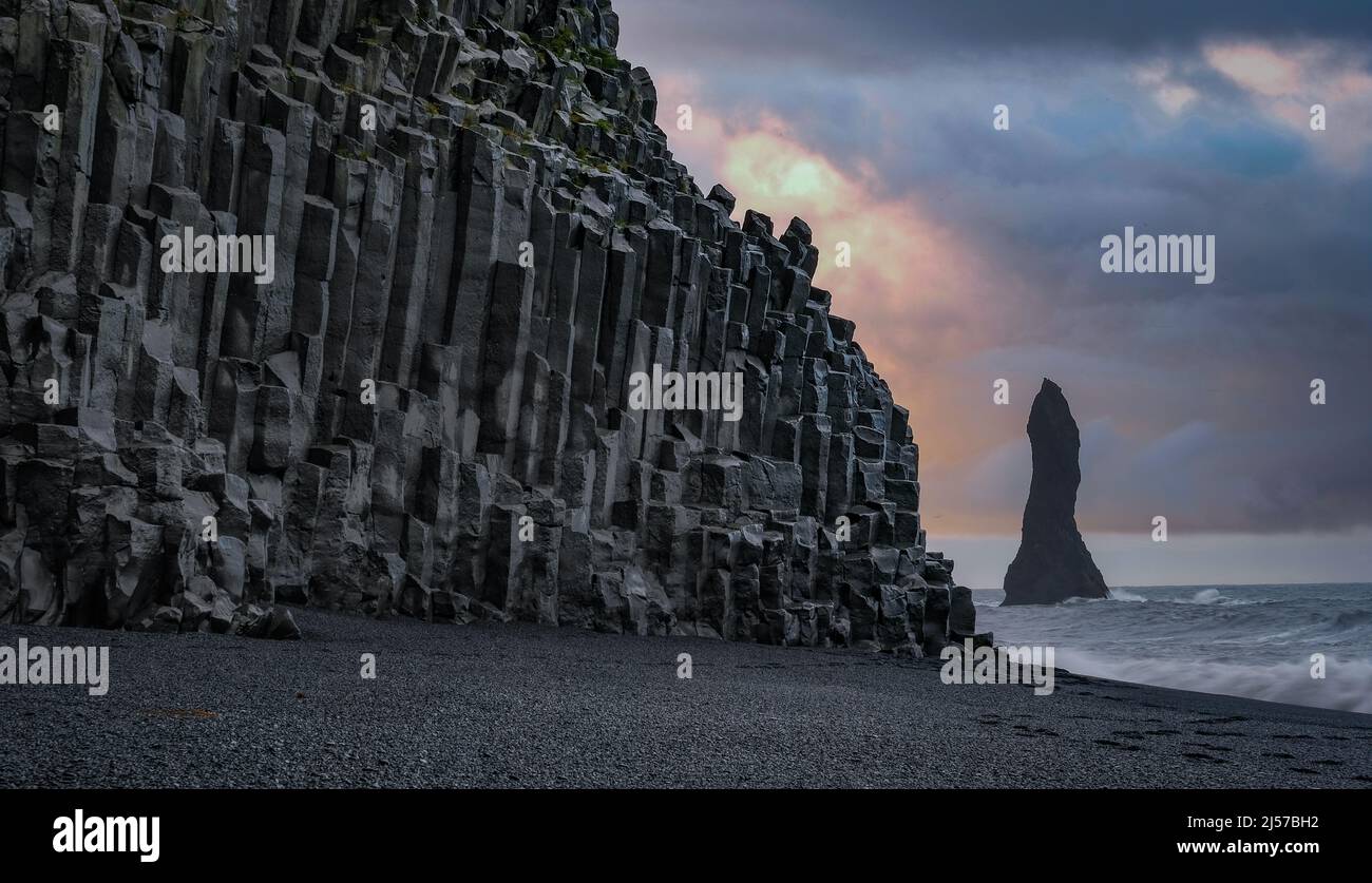 Schwarzer Strand Reynisfjara mit Basaltsäulen, Foto in der Morgendämmerung aufgenommen. Im Hintergrund einer der Reynisdrangar-Felsen. Stock Photo