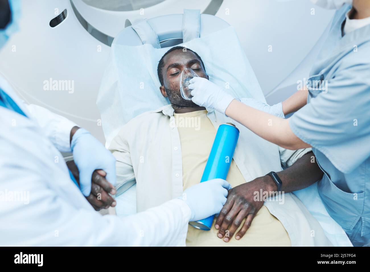 Directly above view of doctors giving oxygen mask to Black patient with