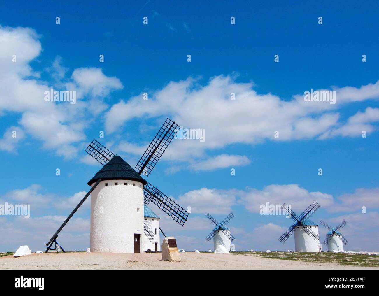 Famous Old Spanish Windmills Campo de Criptana against Blue Cloudy Sky Outdoors. Castilla La Mancha, Spain Stock Photo