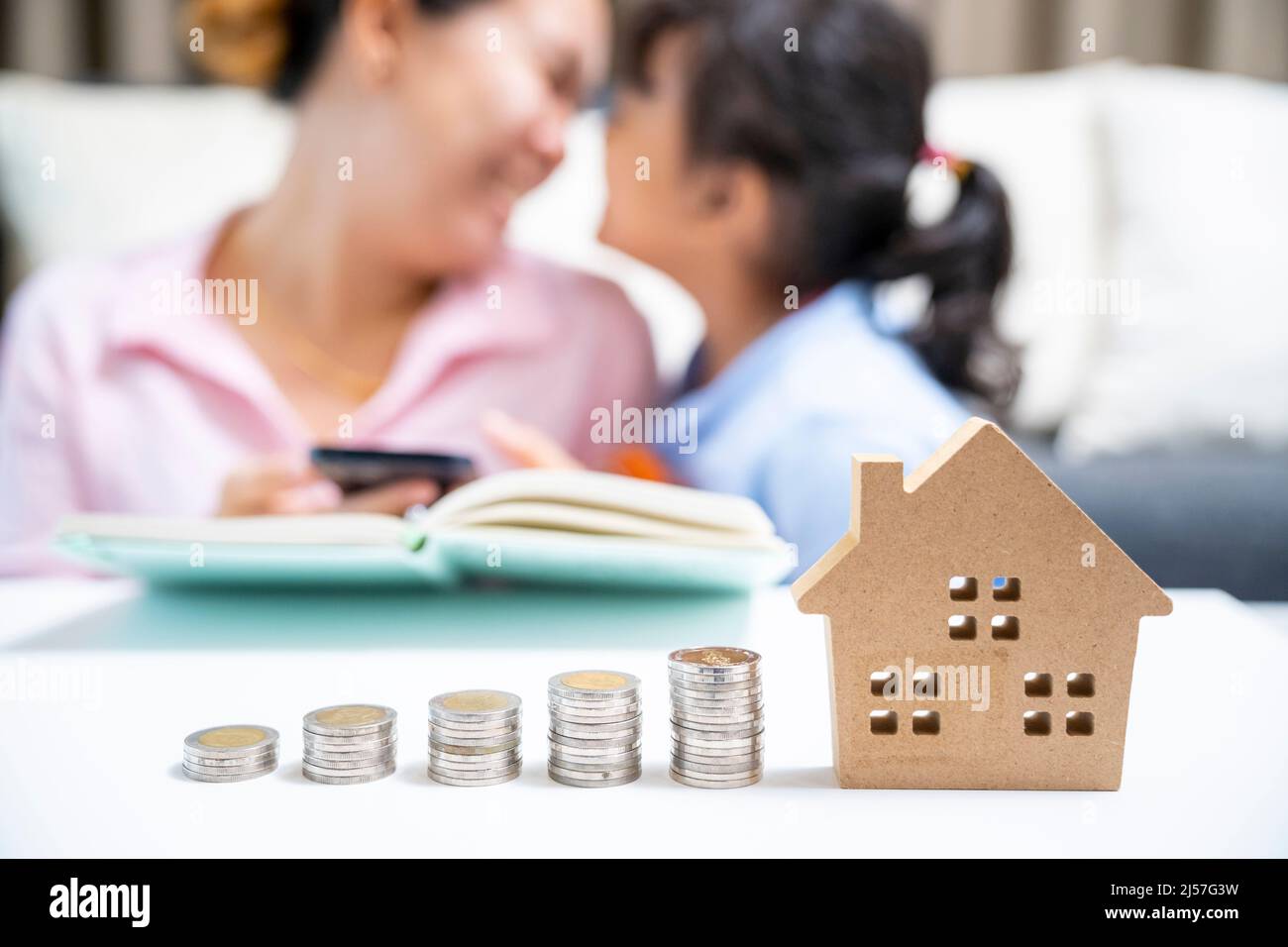 Mother and daughter with money saving for new home Stock Photo - Alamy