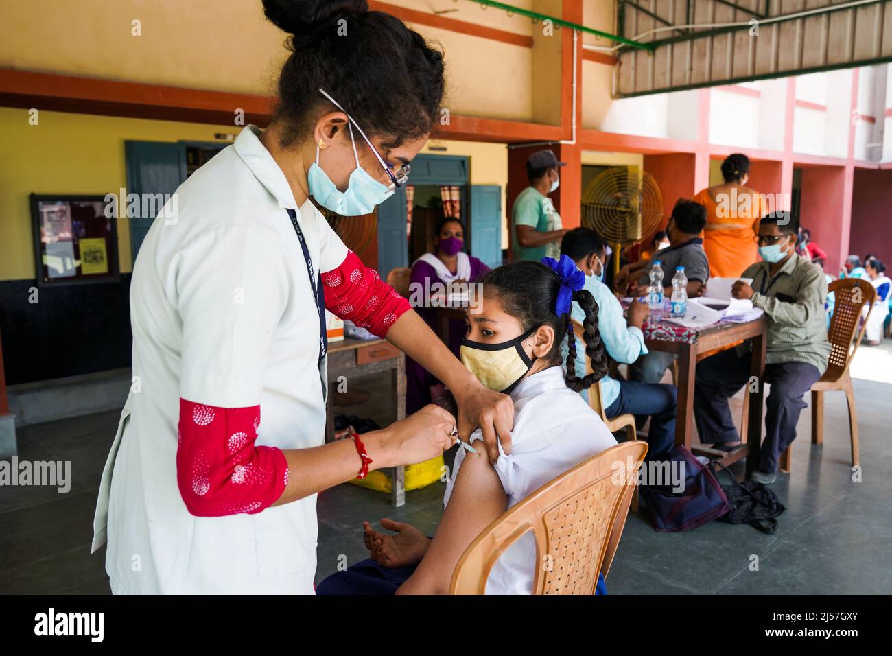 Vaccination in India, Medical worker giving Sinopharm vaccine injection to protect from coronavirus or covid-19 to a girl at Carmel High School for Girls in Baruipur, India Stock Photo