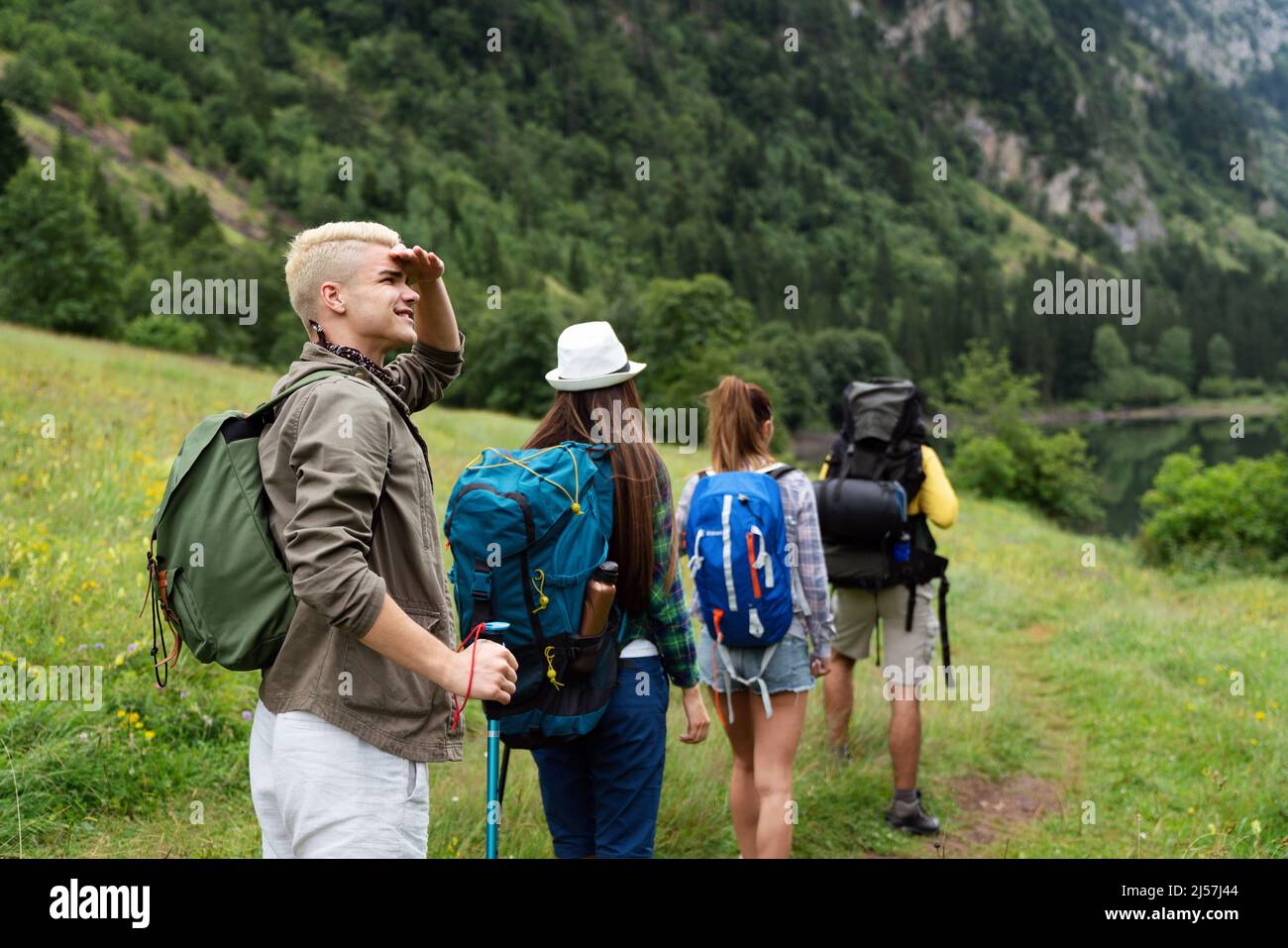 Group of happy friends with backpacks hiking together Stock Photo - Alamy