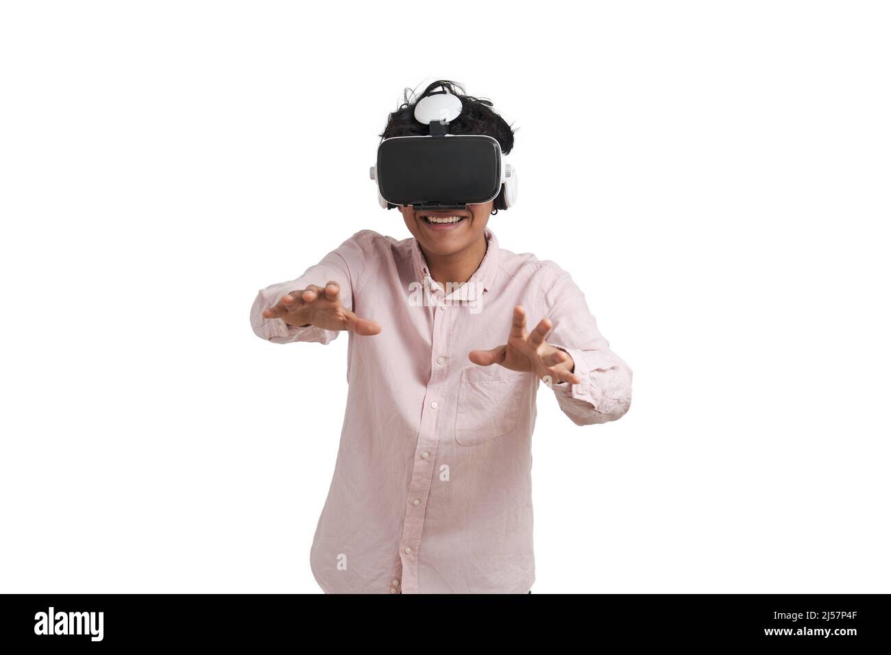 Young peruvian man laughing using virtual reality headset, isolated. Stock Photo