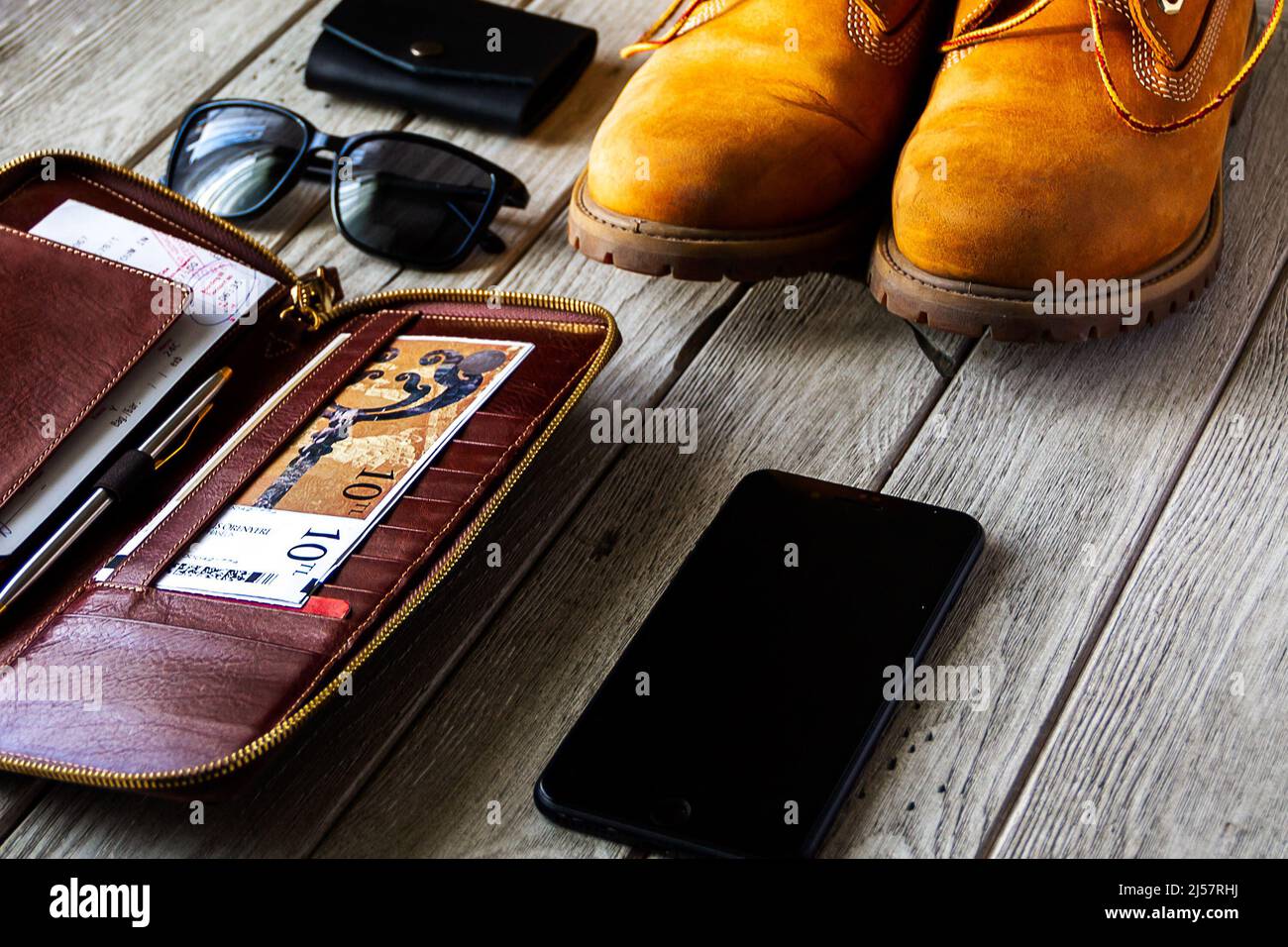 Travel photo. Tracking boot , tickets wallet, smartphone and sunglasses
