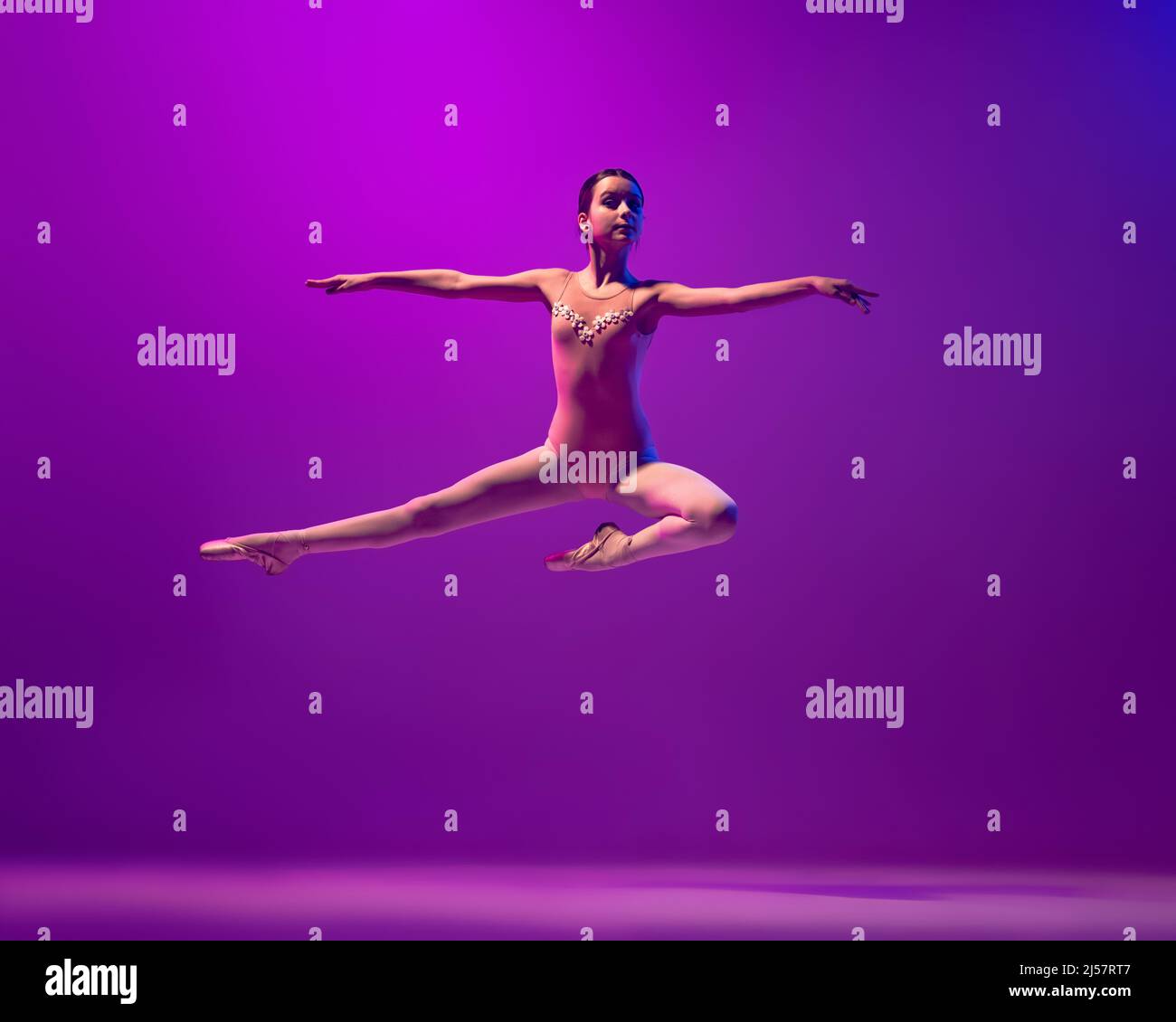 Cute little ballerina in a lilac dress and white tights in white ballet  flats doing leg stretches Stock Photo - Alamy