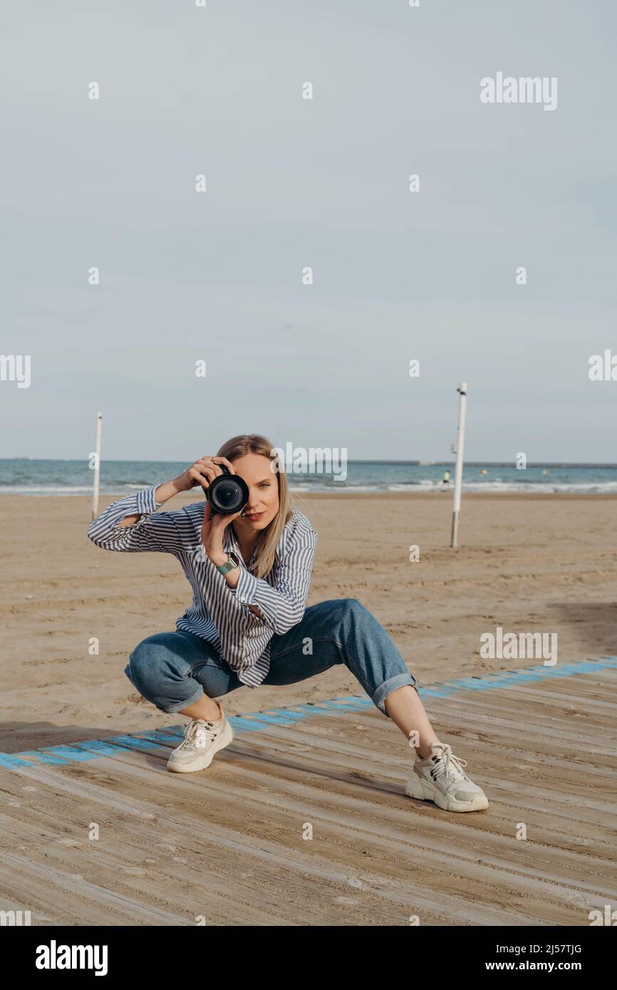 woman photographer on the beach with camera Stock Photo - Alamy