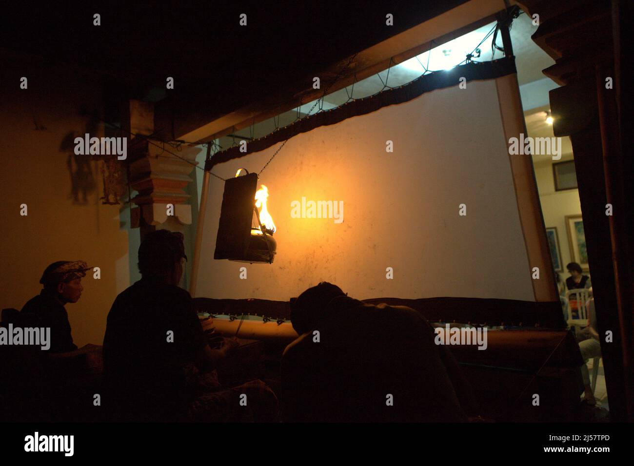 A puppet master and his assistants behind the screen before shadow