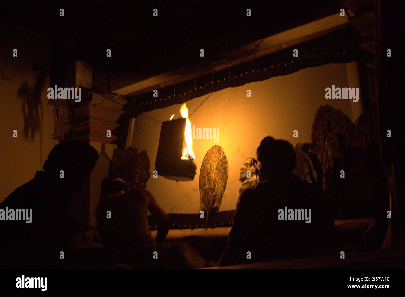 Puppet master and his assistants behind the screen after shadow puppet