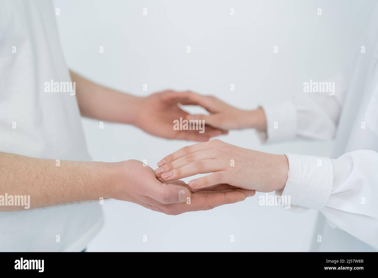 Cropped view of young couple holding hands isolated on white Stock ...