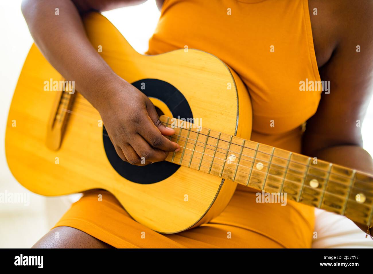 african american teenage girl practicing her skill on acoustic guitar Stock Photo