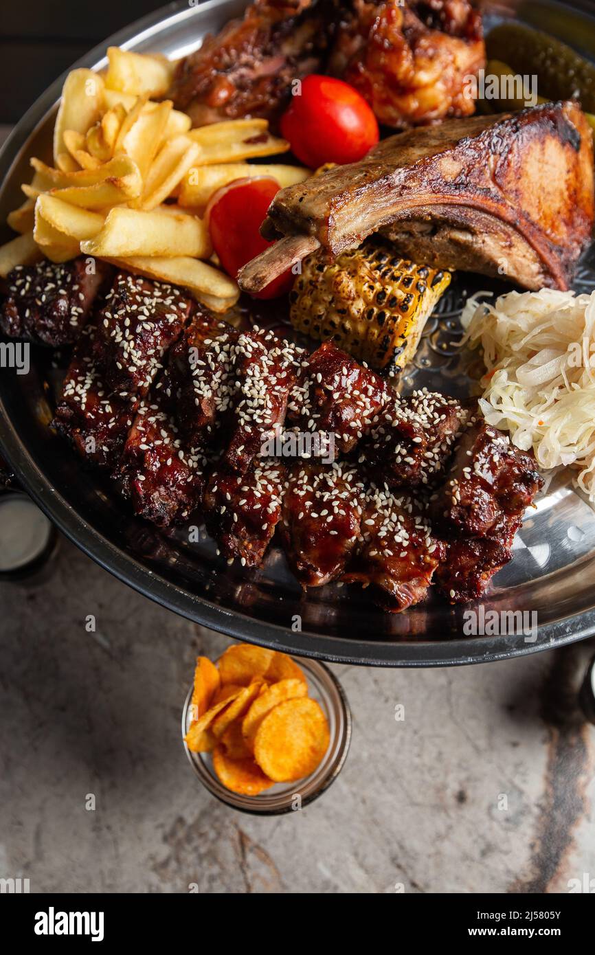 Delicious meats plate, pork ribs, grilled chicken, sausage, beef ...
