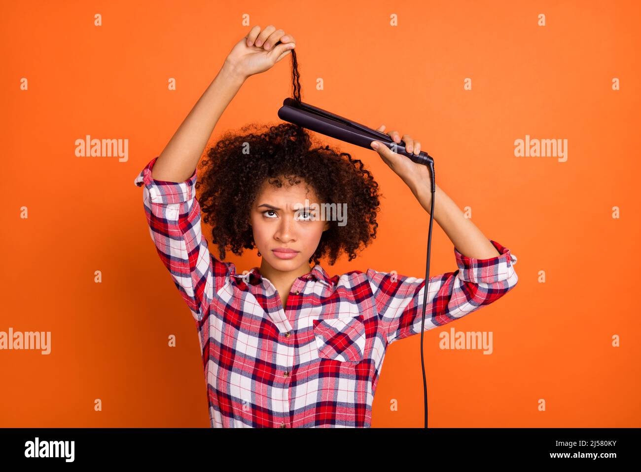 Photo of young grumpy wavy lady straight hair look up wear red shirt isolated on orange color background Stock Photo