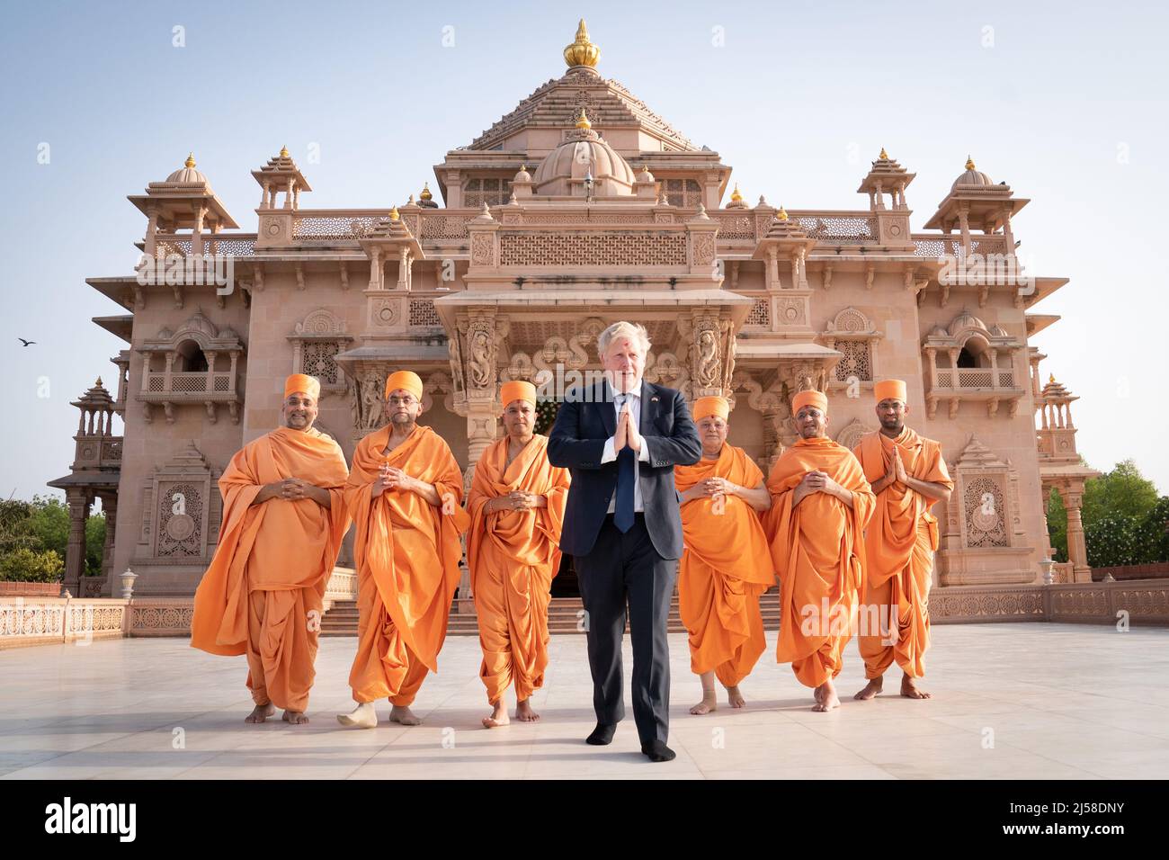Shoeless Prime Minister Boris Johnson walks with sadhus, Hindu holymen, as he visits the Swaminarayan Akshardham temple in Gandhinagar, Ahmedabad, as part of his two day trip to India. Picture date: Thursday April 21, 2022. Stock Photo