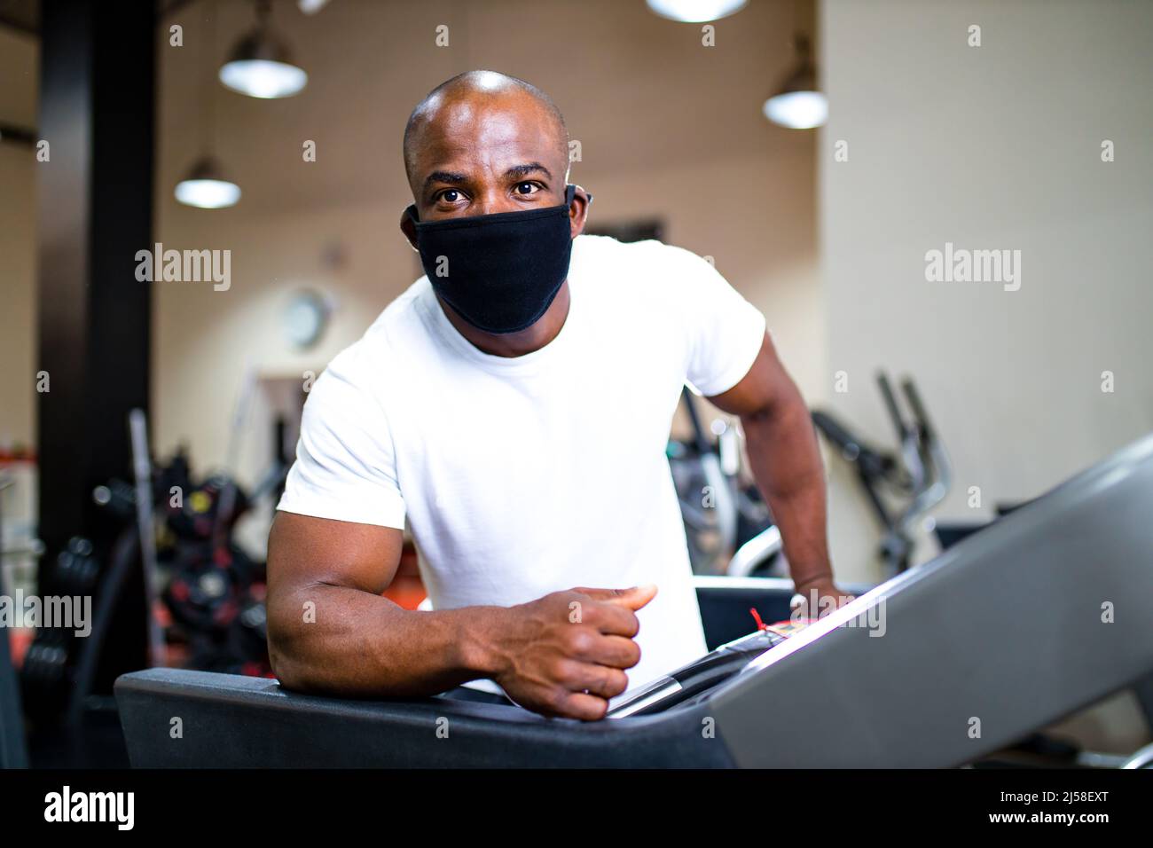 spain man in white cotton t-thirt wearing mask while working out in gym Stock Photo