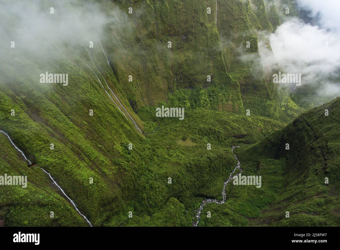 Waterfalls plummet thousands of feet on the Weeping Wall or Wall of Tears on Wai'ale'ale to form the headwaters of the Wailua River on Kauai, Hawaii. Stock Photo