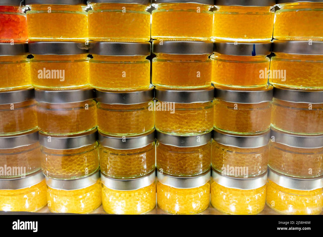 Small glass cans with real fish salmon and trout red, orange and yellow ...